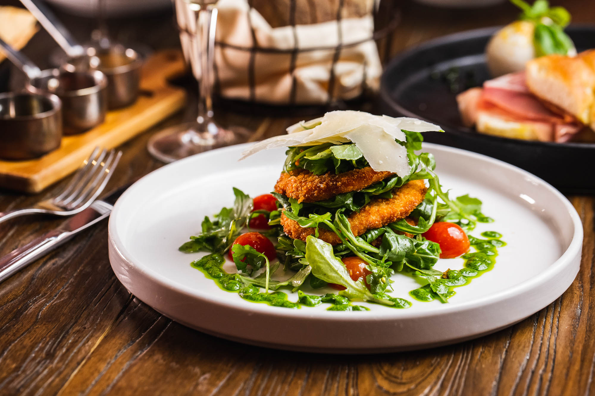 Chicken Milanese  topped with arugula, cherry tomatoes, and shaved Parmesan