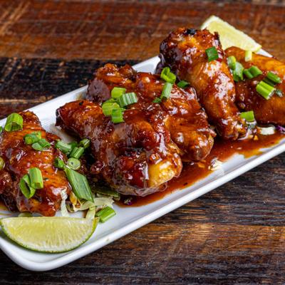 Special Chicken Wings topped with green onions and served with lime wedge.