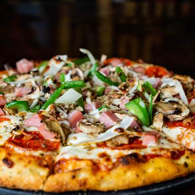 Supreme pizza with sausage, ham, onions, mushrooms, and bell peppers.
