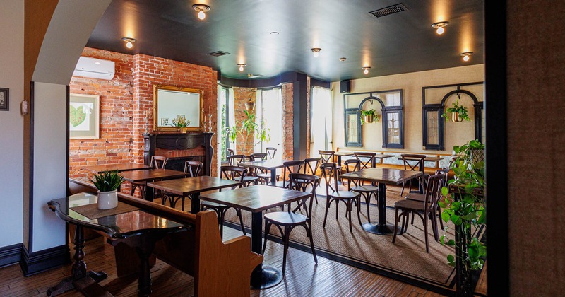 Cozy, rustic room with wooden tables, chairs, and brick walls