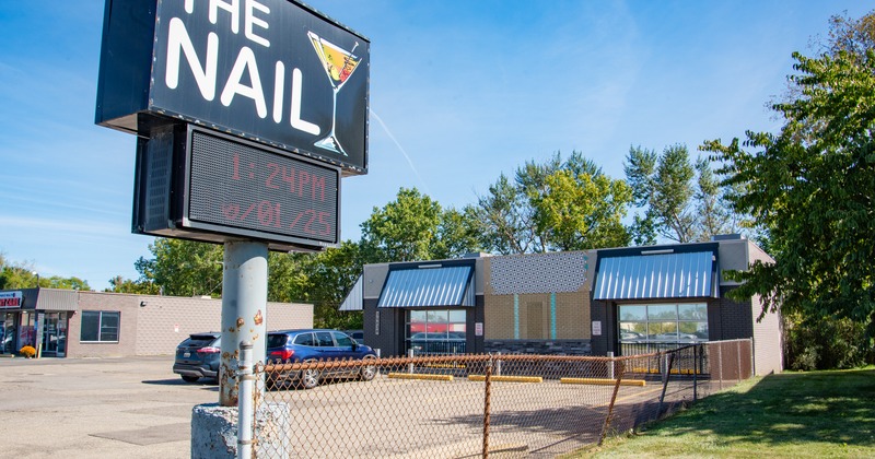Exterior, wide view to restaurant and parking lot, totem sign in front