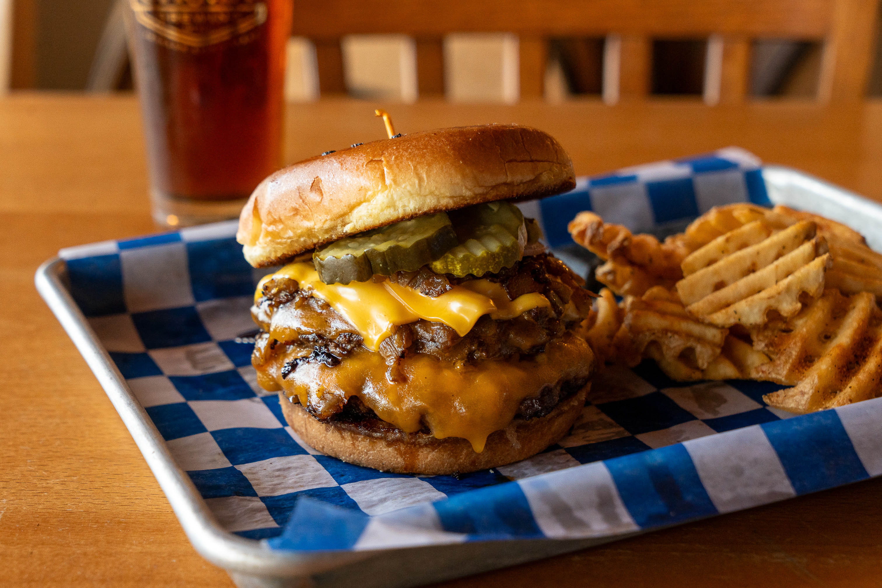 Double smash burger with cheese, pickles, and a side of waffle fries