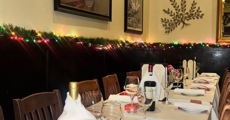 A festive restaurant interior featuring a long dining table set for a celebratory meal