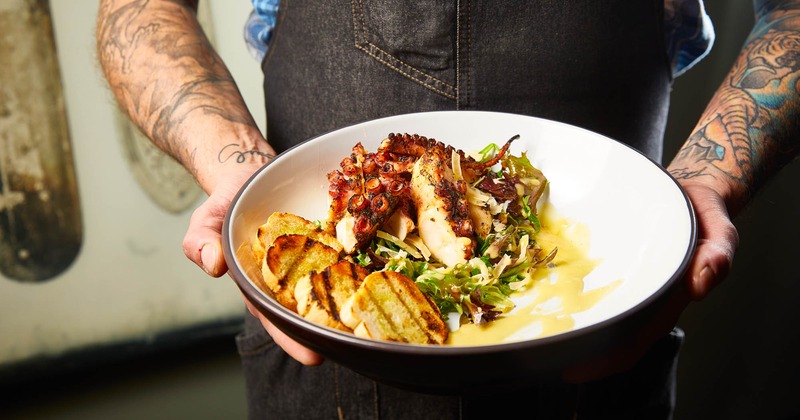 A hand carrying a meal on a plate