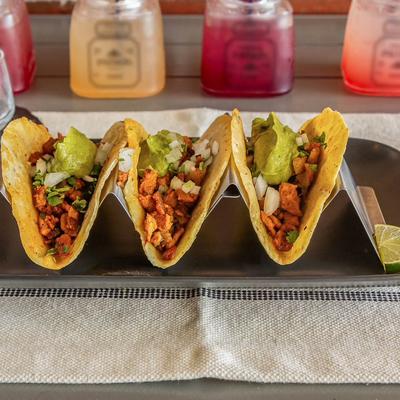 Street tacos with seasoned meat, onions, cilantro, and guacamole.