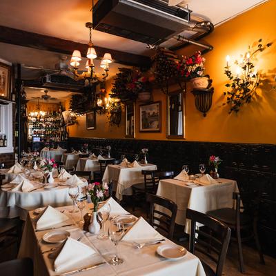 Interior, set tables with folded napkins and vases with fresh cut flowers.