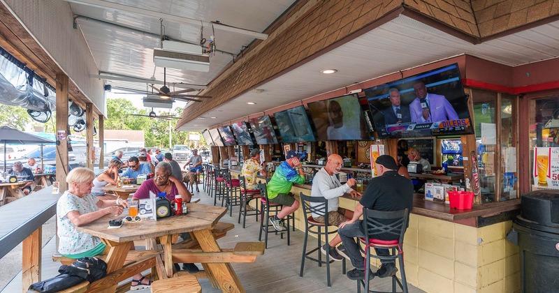 Covered patio full of guests chatting and enjoying their drinks