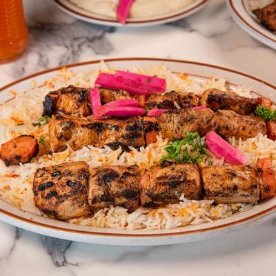 Grilled chicken kebabs over seasoned rice.