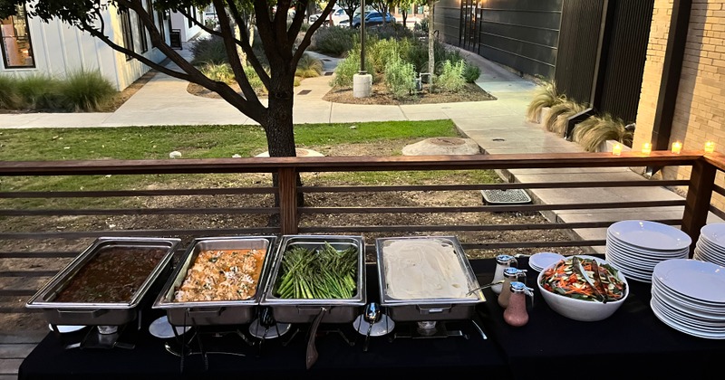 Buffet spread on the patio  table, chafing dishes, salad, tableware