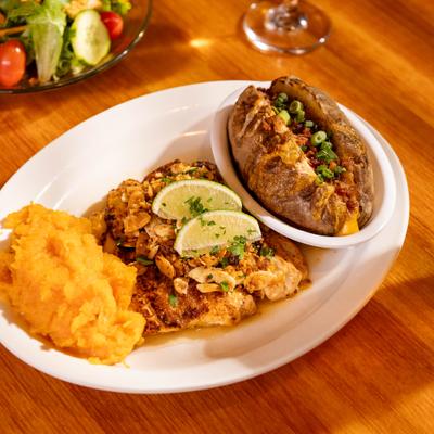 Chicken breast topped with salsa and with mashed potatoes.