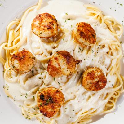 Spaghetti in Alfredo sauce topped with scallops.