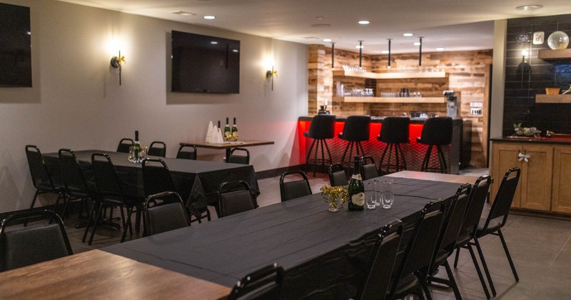 Interior with bables set for dining and bar area in the background