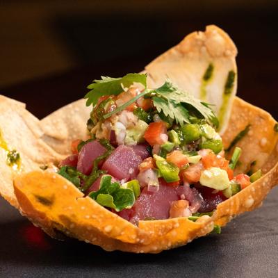 Spicy Tuna Tartare, with avocado salsa, and cilantro, served on a wonton bowl.