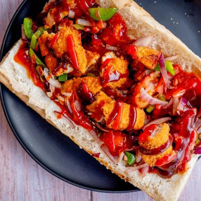 Joes Bomb sandwich with BBQ breaded chicken, cooked vegetables and sauces.