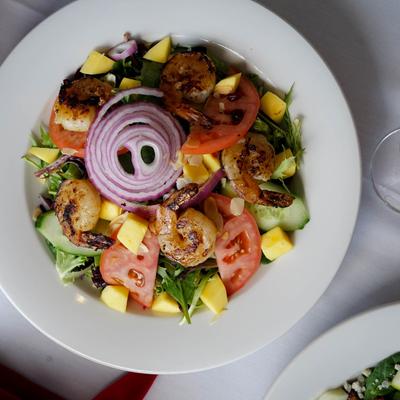 Shrimp salad with tomatoes, mixed greens and red onions
