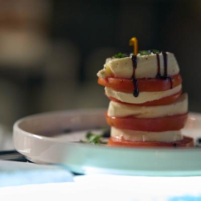 Caprese salad with layers of tomatoes, mozzarella cheese and balsamic glaze.