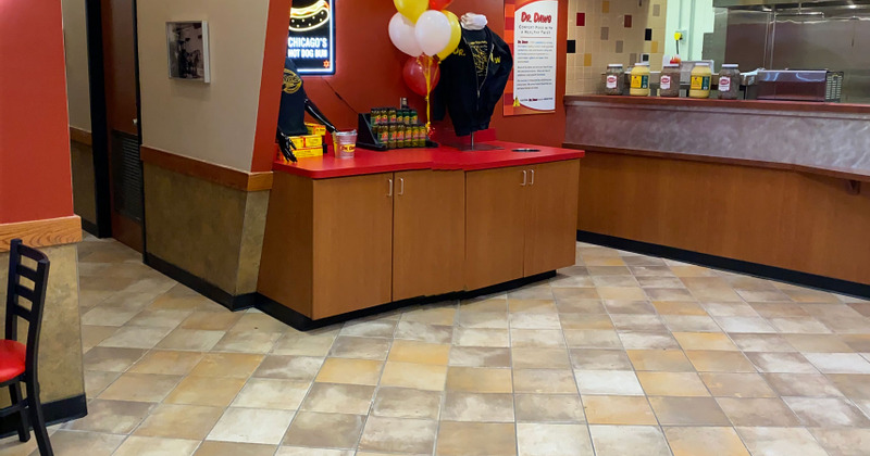 Indoor, area next to counter, promotional t-shirts and bottled drinks on top