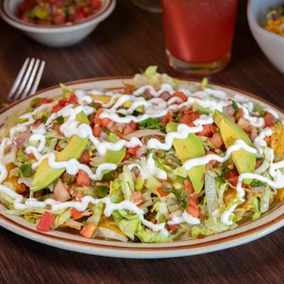 Nachos with chorizo, black beans, cheese, lettuce, sour cream avocado, and tomato salsa.