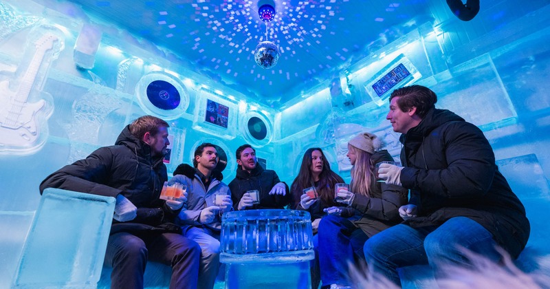 An ice-themed room with blue lighting, featuring records and photos on ice walls