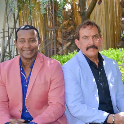 The owners in colorful blazers posing for a photo.