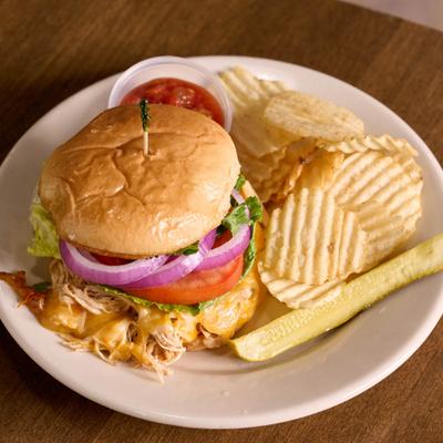 Shredded chicken taco sandwich with sides, served on the table.