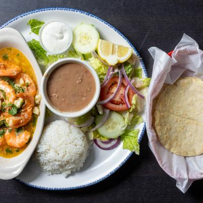 Shrimp in garlic sauce, served with salad, rice, beans, and tortillas.