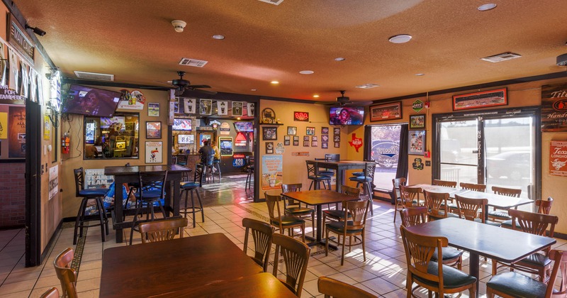 Interior, tables ready for guests, guests sitting at the bar