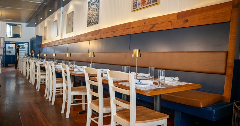 Cozy interior dining area with lined-up dining tables set for guests