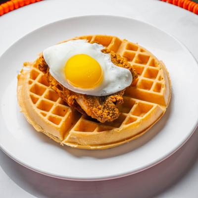 Chicken and waffles topped with fried egg.