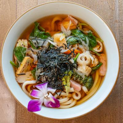 Wide noodles, fishcakes, fresh vegetables in clear broth.