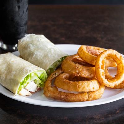 Grilled Chicken  Bacon Wrap served with onion rings on the side.