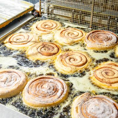 Cinnamon rolls being deep-fried.