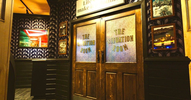 Interior,  double doors labeled 'The Situation Room' surrounded by framed pictures