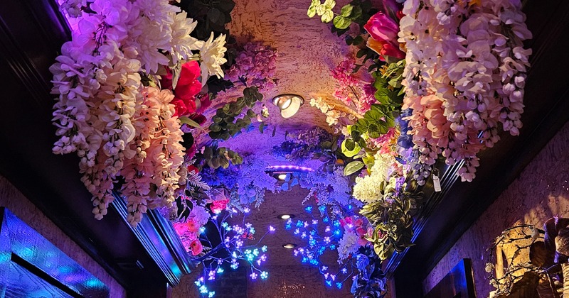Vibey purple hallway decorated with tons of flowers on the ceiling