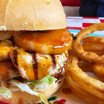 Hawaiian Burger served with onion rings, close up shot.