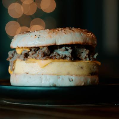Breakfast sandwich with seasoned steak, scrambled eggs, and cheese.