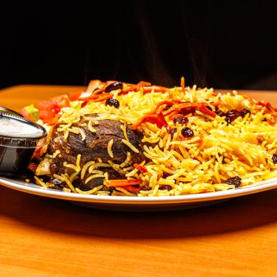 Pilaf with meat served with dressing on the side.