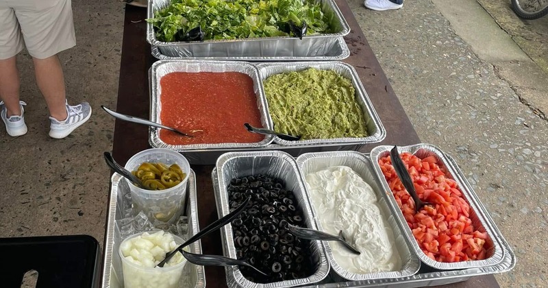 A table with trays of various salad bar toppings