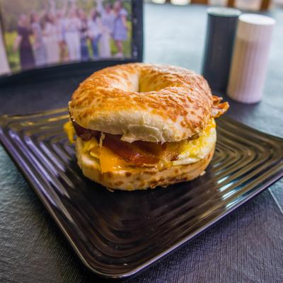 Breakfast sandwich with an egg, cheese, and bacon on a toasted bagel.