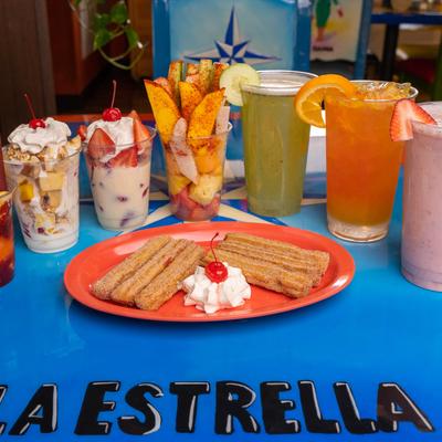 Churros, with various dessert cups and cocktails.