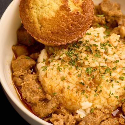 Beef tips over rice, served.