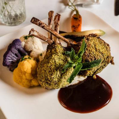 Roasted rack Of lamb with sides, served.
