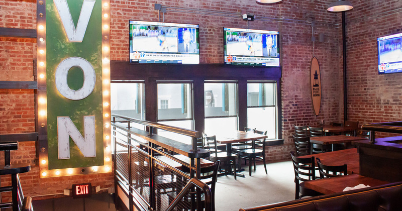 Several TVs mounted on walls in dining area