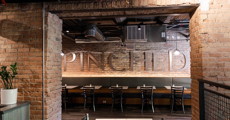 Interior, doorway to dining space, restaurant name sign on a brick wall