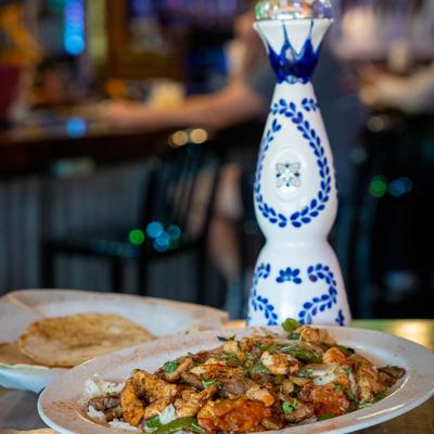 Chicken, steak, and shrimp Fajitas, with onion, peppers, tomatoes, rice, and cheese.