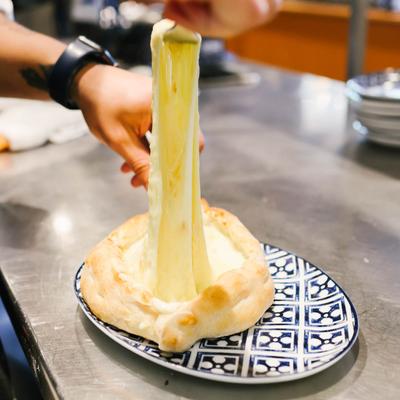 Pulling melted cheese up from a Georgian cheese bread, aka 'khachapuri'