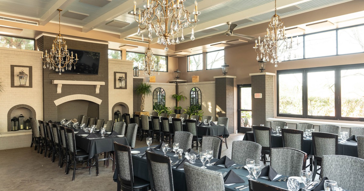 Interior, dining room with long tables, black tablecloths, gray chairs, chandeliers, large windows