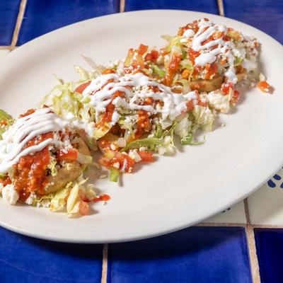 Corn shells topped with beans, meat, lettuce, and sour cream.