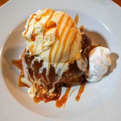 Italian Rum Cake with scoop of ice cream, drizzle of caramel and whipped cream.