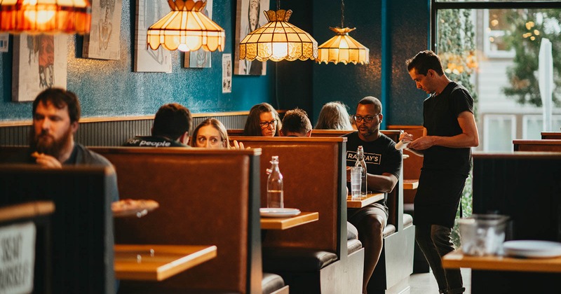 Interior, Inline booths with guests and a server taking an order